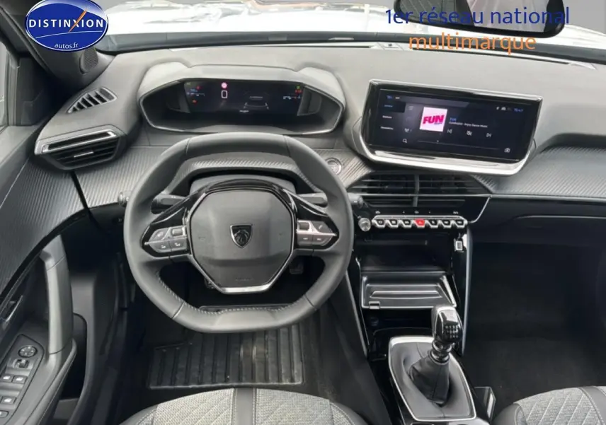 Vue intérieure frontale du poste de conduite du Peugeot 2008 gris Artense, avec volant multifonction et écran tactile central.