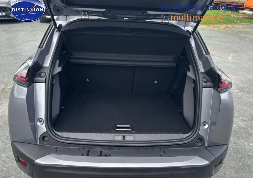 Vue arrière ouverte du Peugeot 2008 gris artense montrant le coffre spacieux et les feux arrière LED.