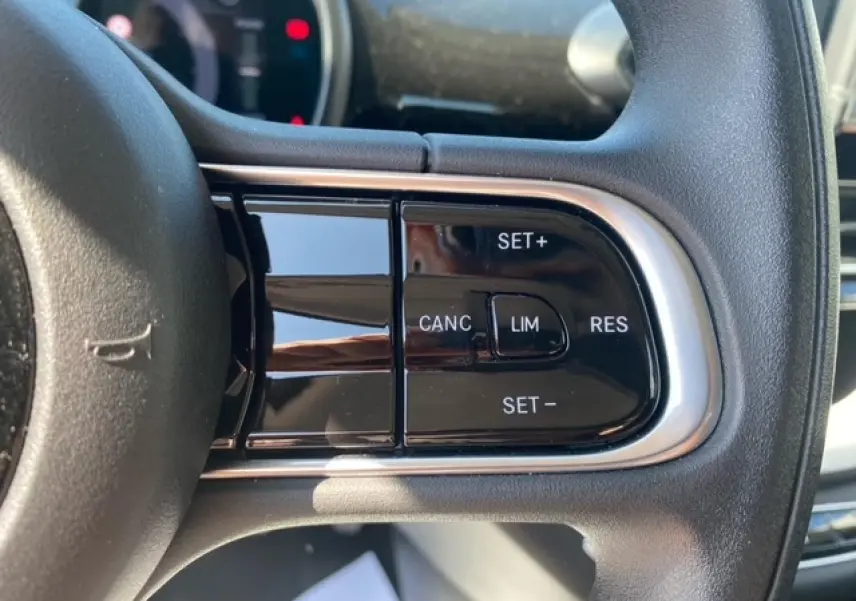 Gros plan sur les commandes de régulateur de vitesse au volant d'une FIAT 500 électrique blanche, version 2022.