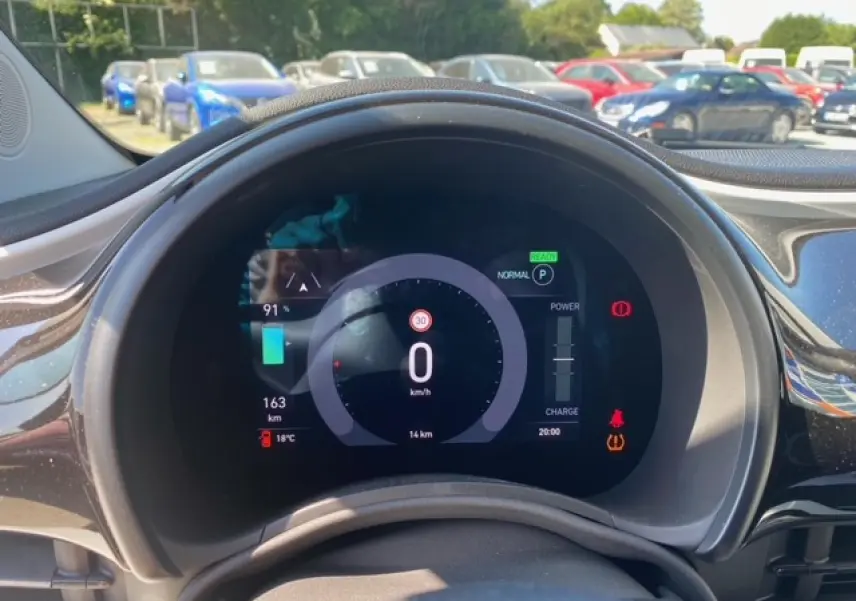 Vue rapprochée du tableau de bord numérique de la Fiat 500 électrique blanche, affichant vitesse et autonomie.