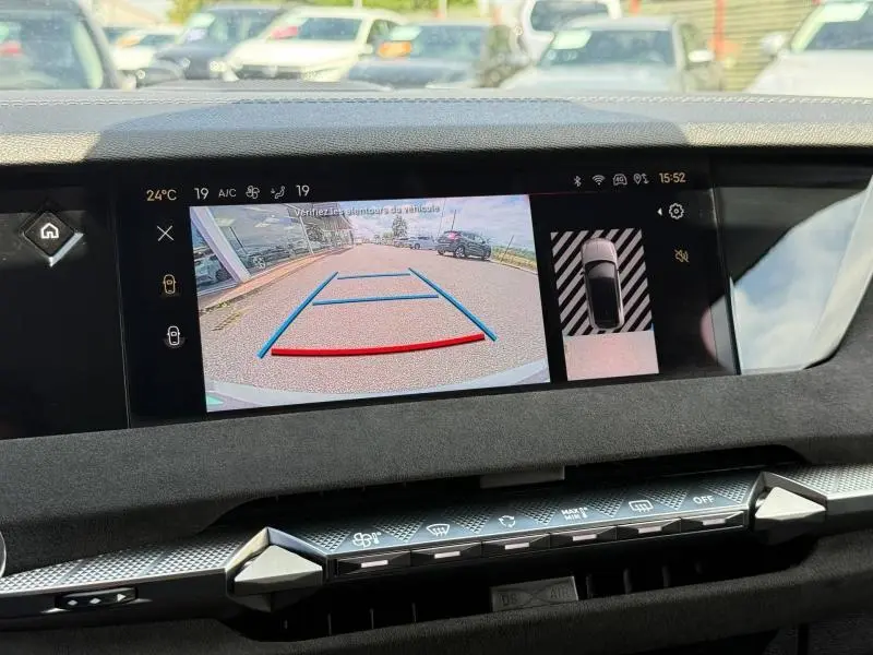 Vue intérieure du tableau de bord du DS4 2024 avec écran tactile affichant la caméra de recul et l'aide au stationnement.