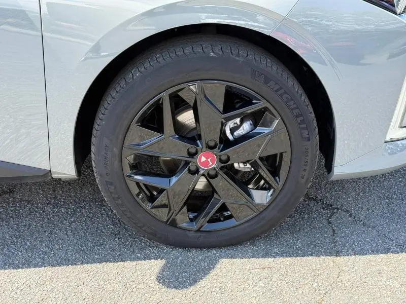 Gros plan sur la roue avant gauche d'une DS4 gris Platinium avec jante alliage noire au design géométrique.