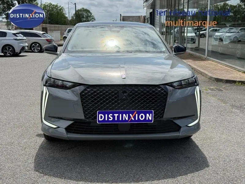 Vue avant d'une DS4 2024 gris Platinium avec calandre noire et feux LED verticaux distinctifs allumés.