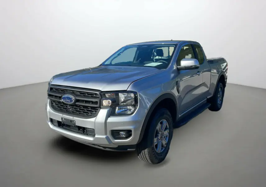 Ford Ranger gris iconic en 3/4 avant droit avec calandre noire et marchepieds latéraux visibles.