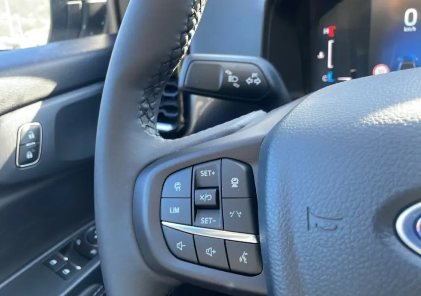 Gros plan sur le volant cuir multifonctions du Ford Ranger gris iconic, avec commandes audio et régulateur de vitesse.