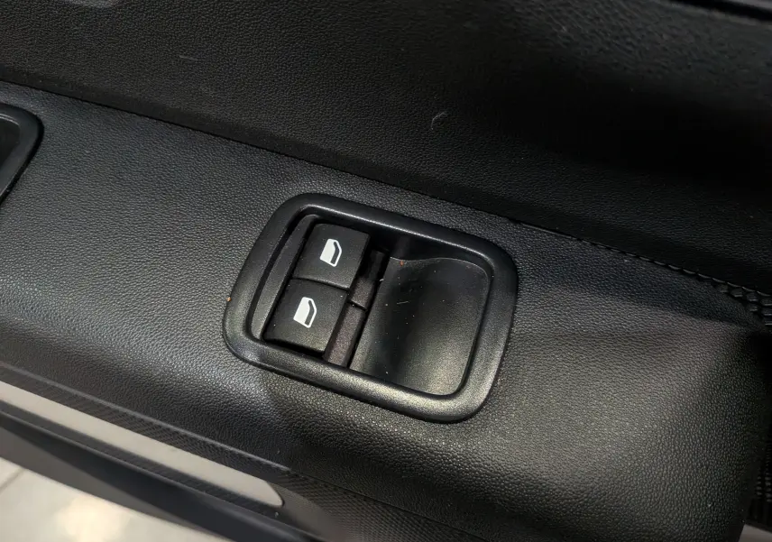 Gros plan sur les commandes de lève-vitres électriques côté conducteur d'une Citroën C3 Société blanc banquise.