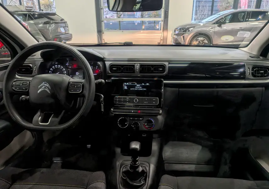 Tableau de bord et volant noir de la Citroën C3 Société BlueHDi 100 vue de face, intérieur tissu et console centrale moderne.