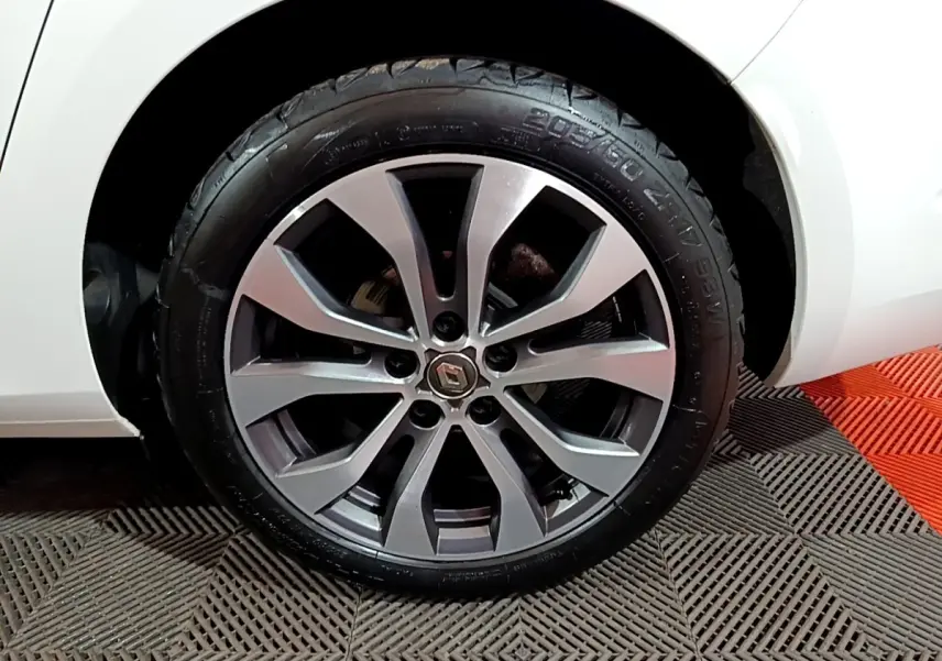 Gros plan sur la roue avant droite de la Renault Mégane blanche 2023 avec jante alliage moderne.