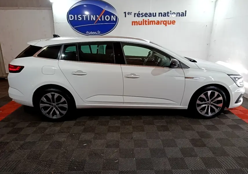 Renault Mégane Techno TCe 140 blanc vue de profil côté gauche, avec jantes alliage et feux arrière LED allumés.