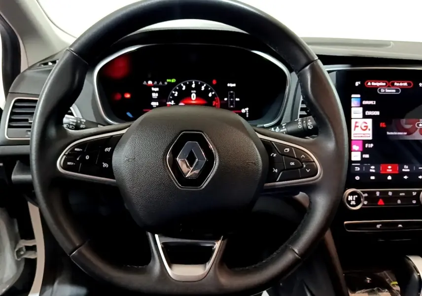 Vue rapprochée du volant noir avec logo Renault au centre et tableau de bord digital de la Renault Mégane 2023.