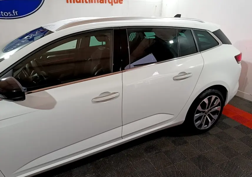 Vue de profil côté gauche d'une Renault Mégane blanche 2023 avec jantes alliage et vitres teintées.