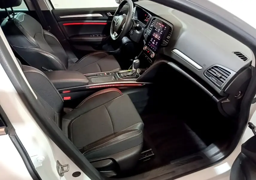 Intérieur avant droit de la Renault Mégane Techno TCe 140 blanc, sièges noirs et éclairage d’ambiance rouge.