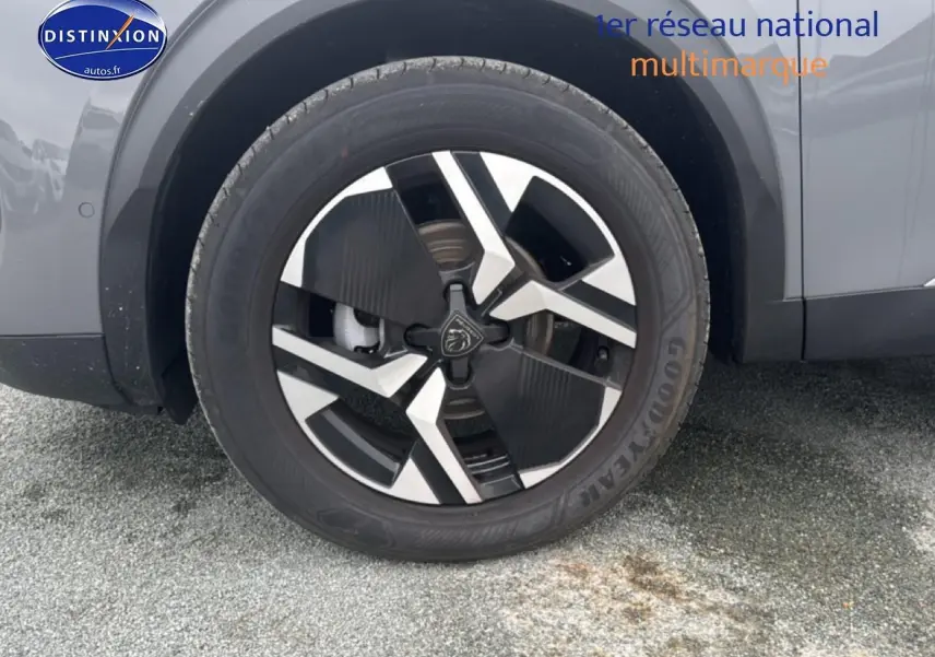 Gros plan sur la roue avant droite d’un Peugeot 2008 gris sélénite avec jante alu au design moderne.