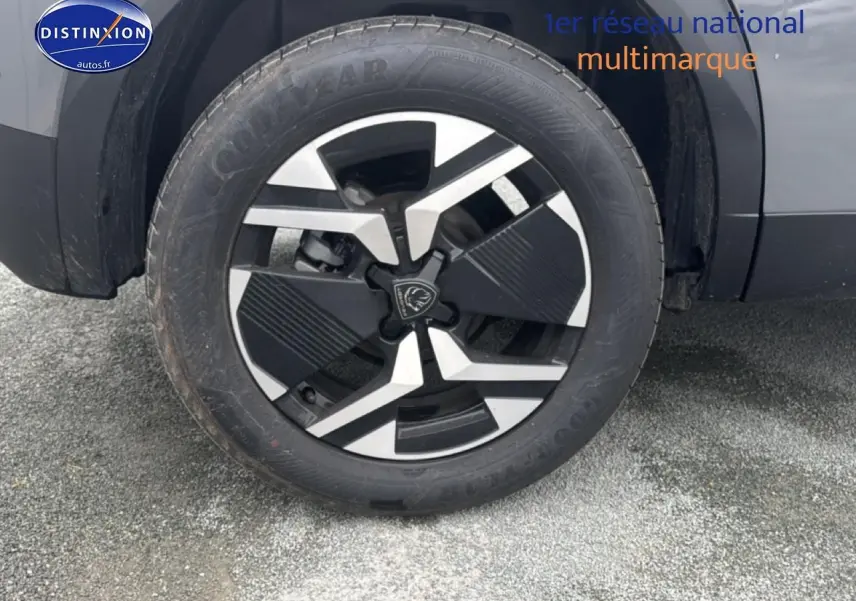 Gros plan sur la roue avant droite avec jante alu noire et argentée du Peugeot 2008 gris sellenium 2025.