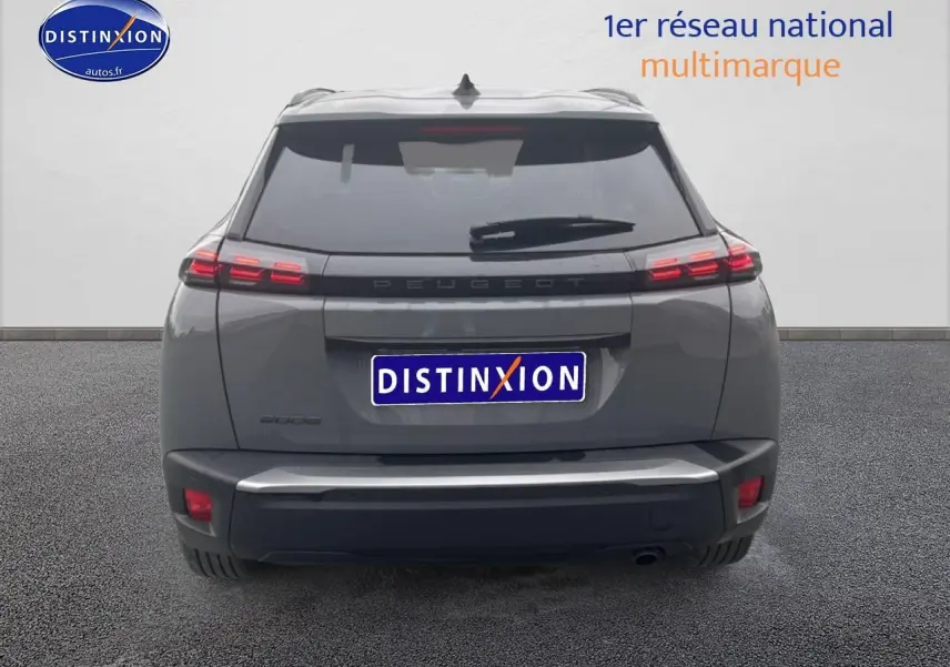 Vue arrière d'un Peugeot 2008 gris sélénite 2025 avec feux arrière à LED et becquet noir.