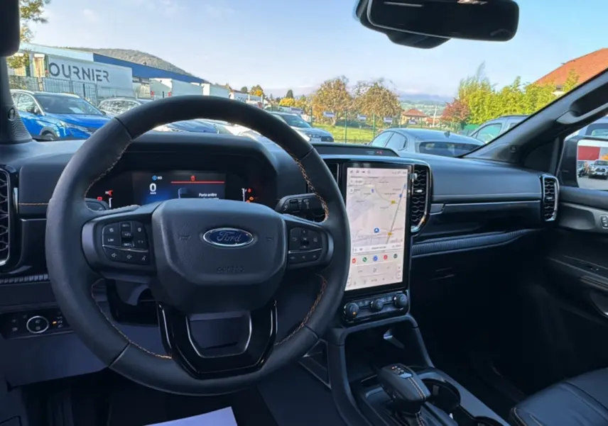 Intérieur du Ford Ranger PHEV 281 Wildtrak 2025 vu depuis le siège conducteur, tableau de bord noir avec écran tactile vertical.