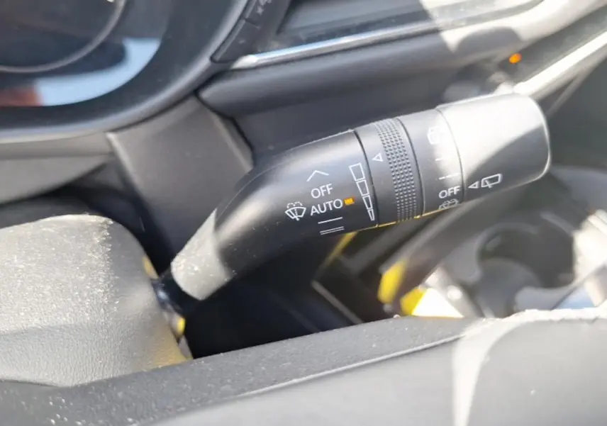 Gros plan sur la commande de l'essuie-glace côté droit du tableau de bord d’un Mazda CX-30 gris 2020.
