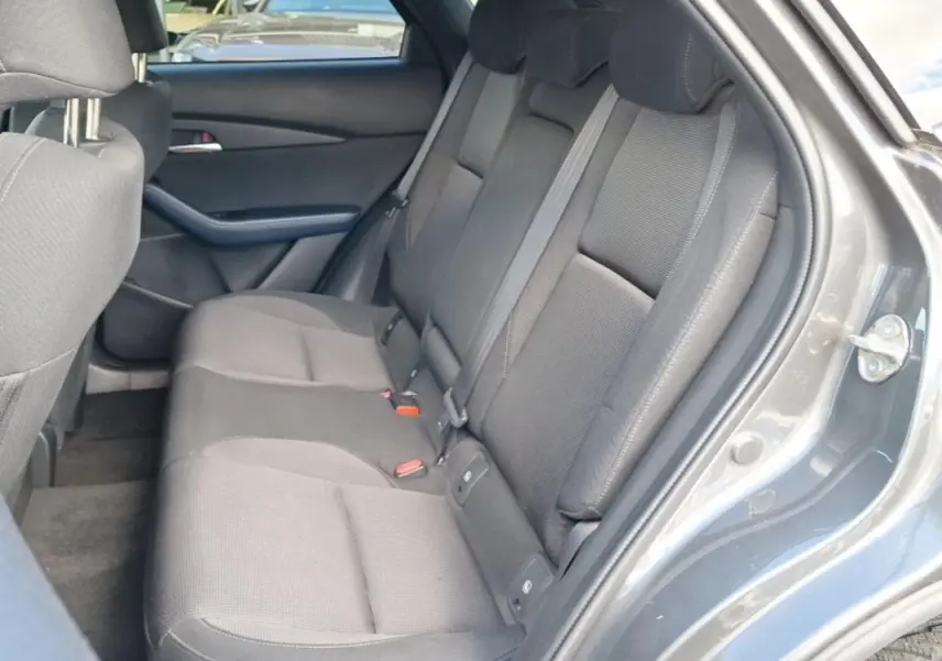 Vue intérieure côté droit des sièges arrière gris foncé du Mazda CX-30 2020 avec porte ouverte et garnitures assorties.