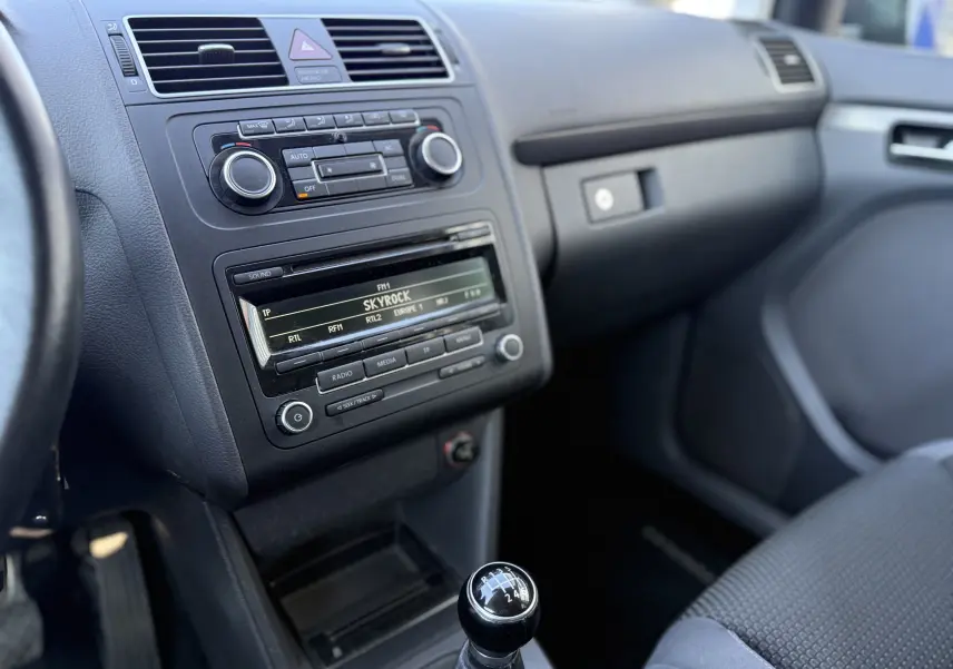 Vue intérieure côté passager du tableau de bord gris et levier de vitesse manuel d’un Volkswagen Touran 1.4 TSI 7 places de 2012.