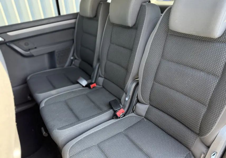 Vue rapprochée des sièges arrière en tissu gris foncé du Volkswagen Touran 2012, version 7 places.