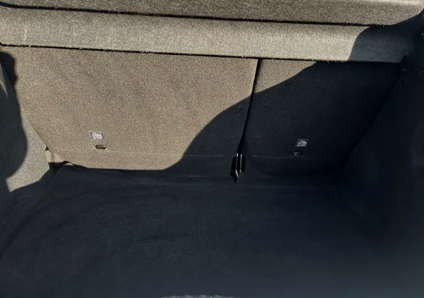 Coffre vide en tissu noir de la Citroën C3 blanche 2019, vue intérieure depuis l'ouverture arrière.