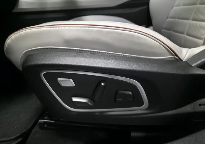 Gros plan sur les commandes électriques du siège avant gris sable clair perforé du Renault Espace 2025.