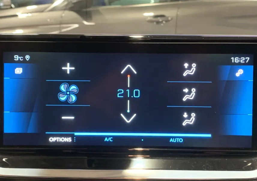 Écran tactile intérieur de la Peugeot 208 gris, affichant la climatisation réglée à 21°C en mode automatique.