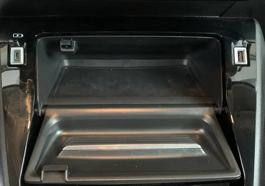 Vue rapprochée de la console centrale noire de la Peugeot 208 PureTech 100 Allure Business, avec ports USB visibles.