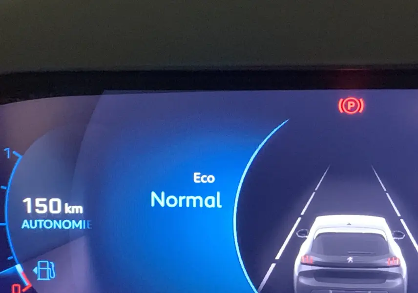 Affichage numérique du tableau de bord d'une Peugeot 208 gris, montrant l'autonomie à 150 km et le mode Eco Normal activé.
