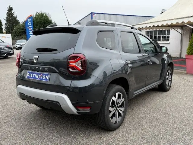 Vue 3/4 arrière droite d’un Dacia Duster 2022 gris comète avec feux LED et jantes alliage distinctives.