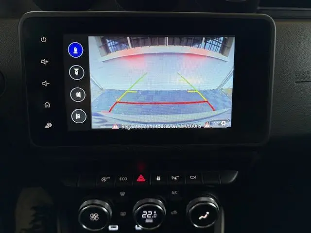 Écran de caméra de recul affichant l’arrière du Dacia Duster gris Comète avec les lignes de guidage colorées.