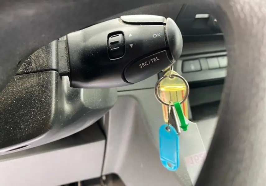 Gros plan sur la commande au volant noir du Citroën Jumpy blanc, avec clés suspendues visibles en intérieur.