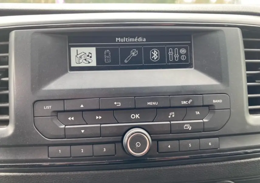 Gros plan sur la console centrale du Citroën Jumpy blanc de 2019, affichant l’écran multimédia et les commandes audio.