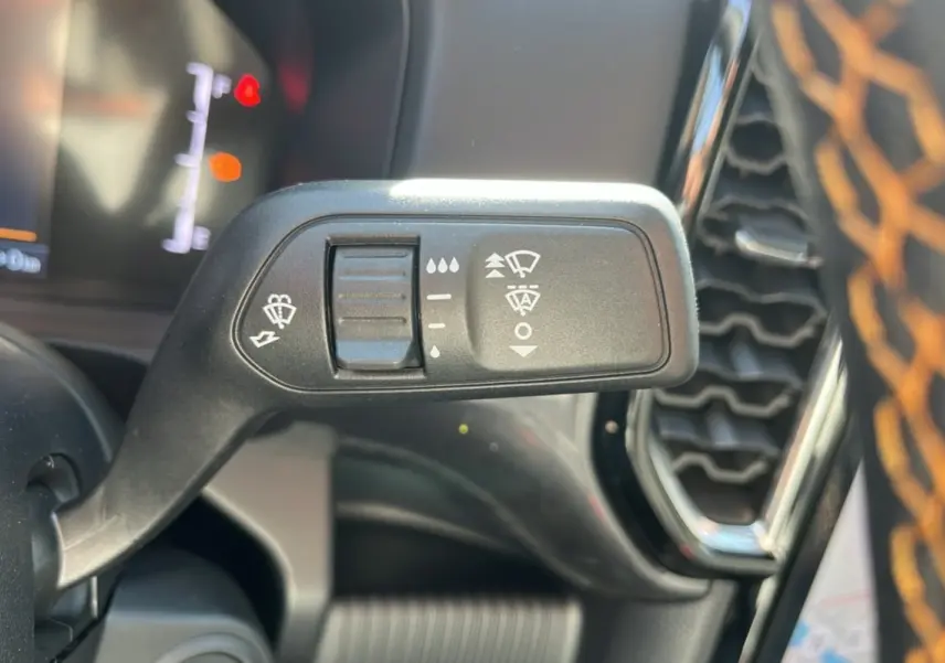 Gros plan sur la commande des essuie-glaces du Ford Ranger PHEV 281 Wildtrak gris carbone, intérieur noir avec surpiqûres orange.