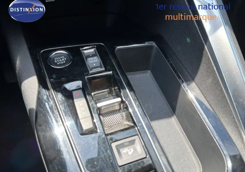 Gros plan sur la console centrale du Peugeot 5008 2023, montrant le levier de vitesses et les commandes de démarrage et mode de conduite.