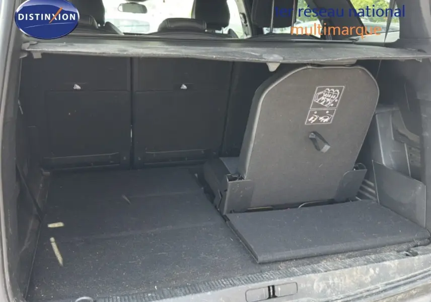 Coffre ouvert du Peugeot 5008 gris Platinium, vue arrière montrant la banquette arrière partiellement rabattue.
