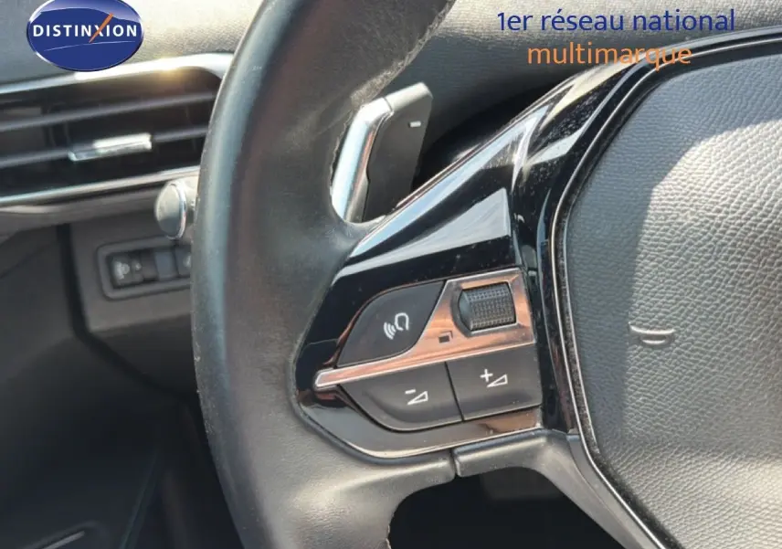 Gros plan sur les commandes gauche du volant cuir noir du Peugeot 5008 2023, finition Allure Pack.