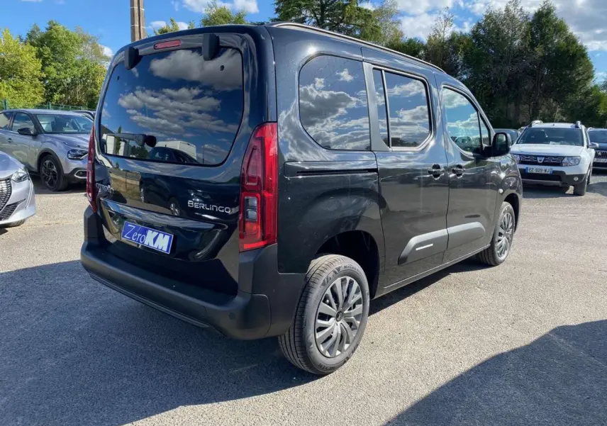 Vue 3/4 arrière droite d'un Citroën Berlingo noir métallisé avec vitres surteintées et hayon arrière vitré.