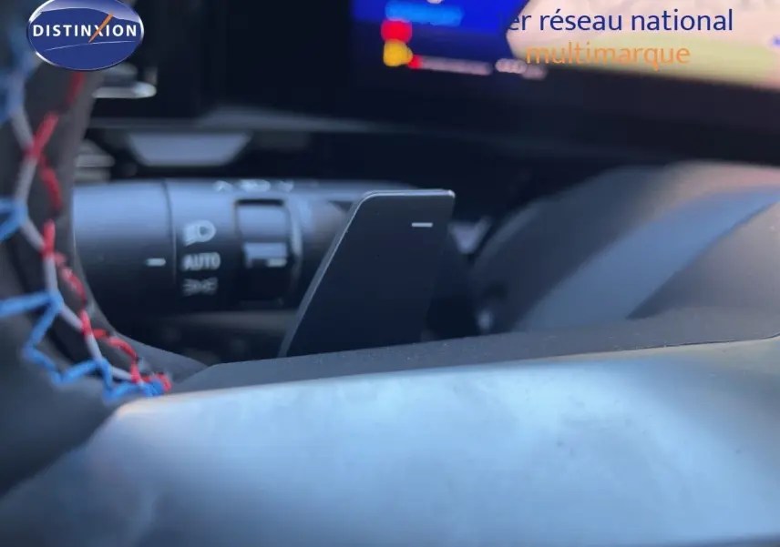 Gros plan sur la palette de changement de vitesse noire et le volant avec surpiqûres tricolores dans le Renault Austral noir étoile métal.