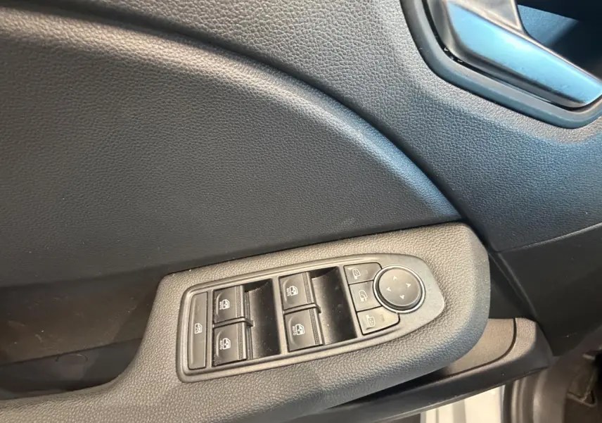 Détail des commandes de lève-vitres et rétroviseurs sur la porte côté conducteur d’une Renault Clio blanche 2024.