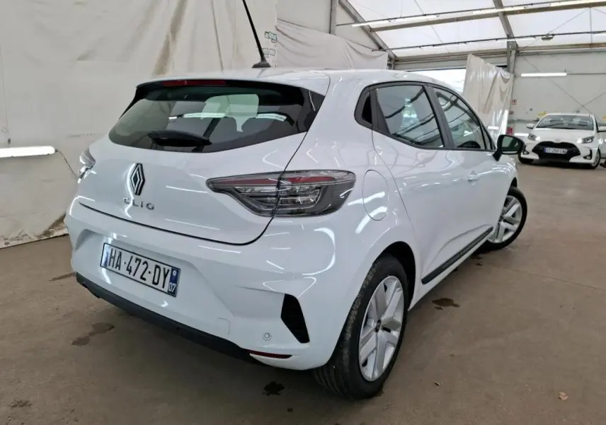 Vue 3/4 arrière droite d'une Renault Clio blanche 2024 avec feux arrière LED et jantes 16 pouces en intérieur.