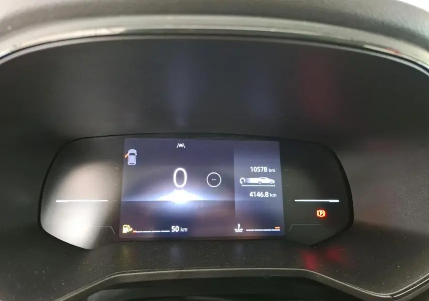 Tableau de bord numérique de Renault Clio blanc 2024 affichant compteur kilométrique et alertes au repos.