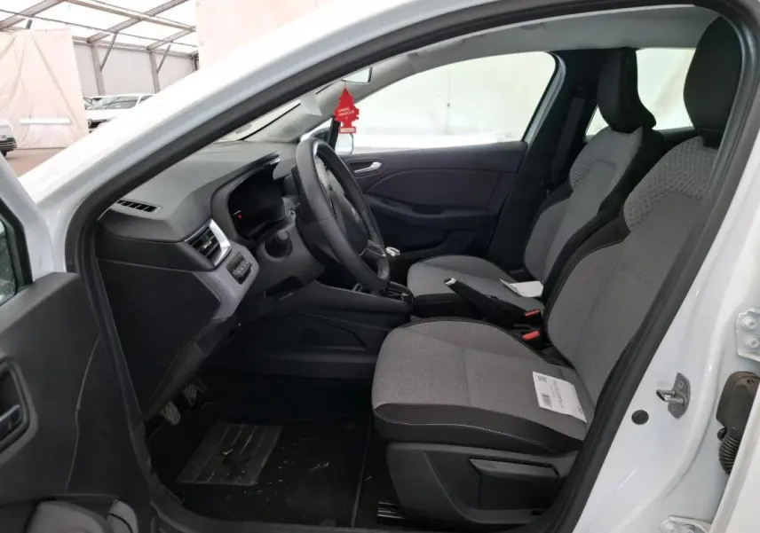 Vue intérieure côté conducteur de la Renault Clio blanche 2024, sièges tissu gris et volant multifonction.