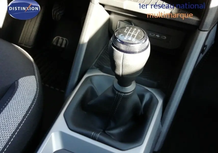 Gros plan sur le levier de vitesse manuel du Dacia Duster TCE MHEV 140ch Journey, intérieur noir et gris.