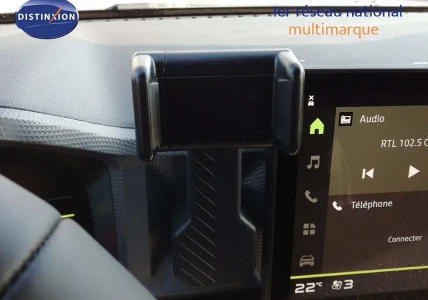 Vue intérieure centrée sur la console centrale du Dacia Duster gris schiste métal, avec écran tactile et support smartphone.
