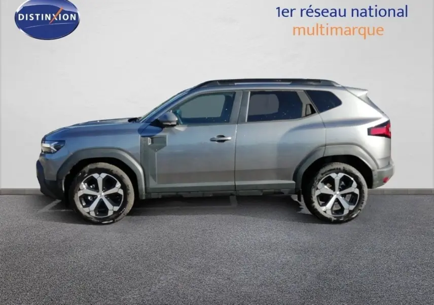 Profil droit du Dacia Duster TCE MHEV 140ch Journey gris schiste métal avec jantes bicolores et lignes robustes.