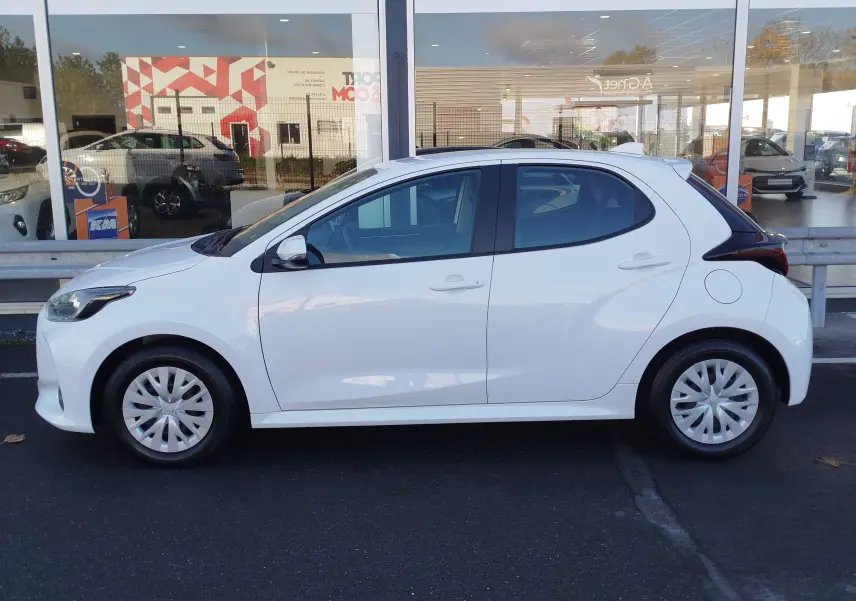 Profil droit d'une Toyota Yaris blanche 2023, compacte avec jantes pleines et vitres teintées.