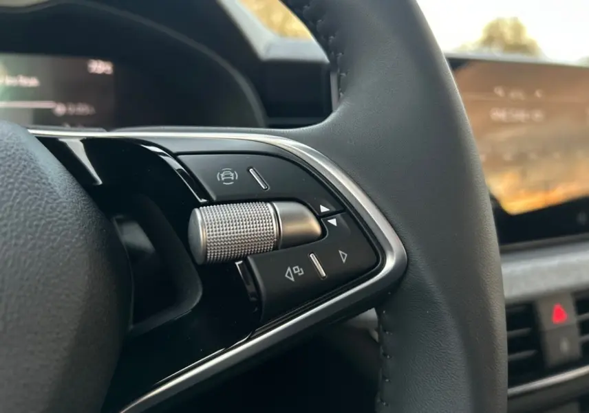 Gros plan sur les commandes multifonctions en aluminium du volant cuir du Skoda Kamiq gris clair 2025.