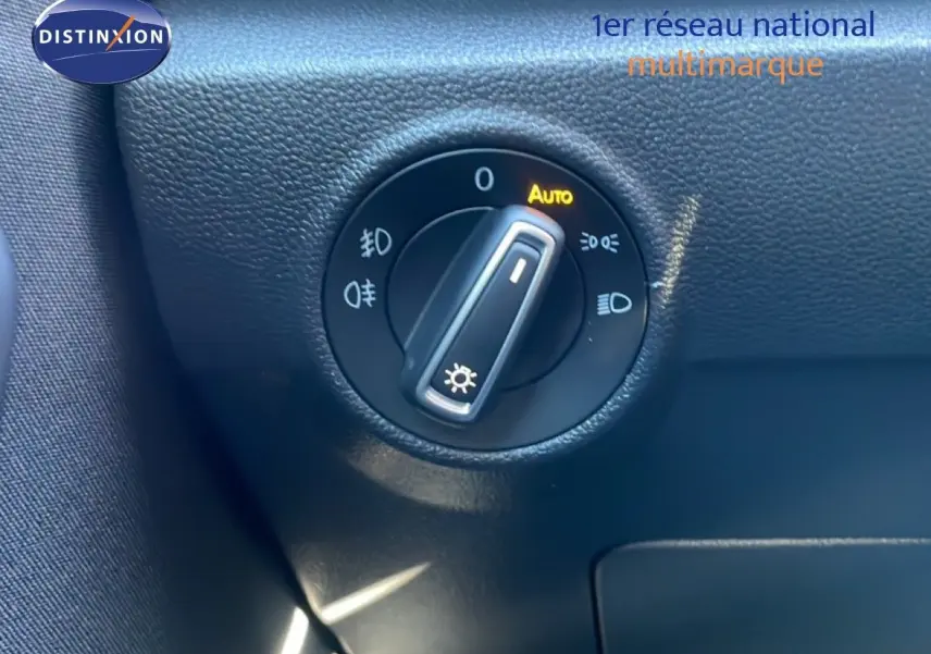 Gros plan sur le sélecteur de phares noir avec fonction Auto, intérieur du Volkswagen T-Roc bleu Ravenna 2021.