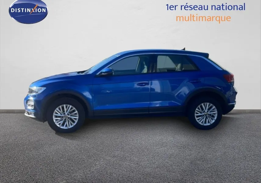 Vue de profil côté gauche d'un Volkswagen T-Roc bleu Ravenna métallisé, avec jantes alliage et carrosserie compacte.